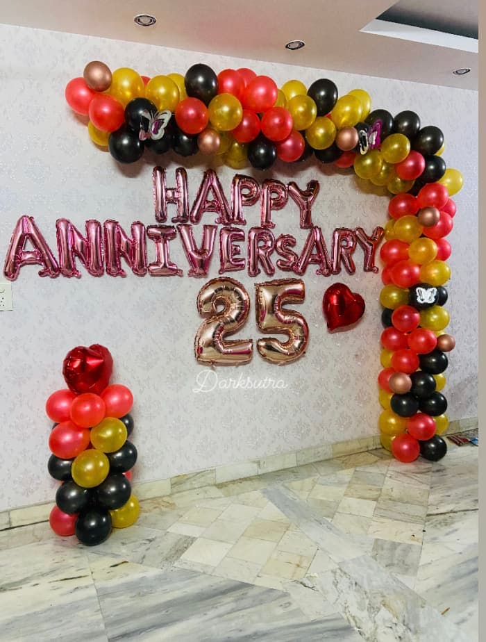 Red, gold and black balloon arch with rose gold HAPPY ANNIVERSARY letters, number 25 and heart balloons