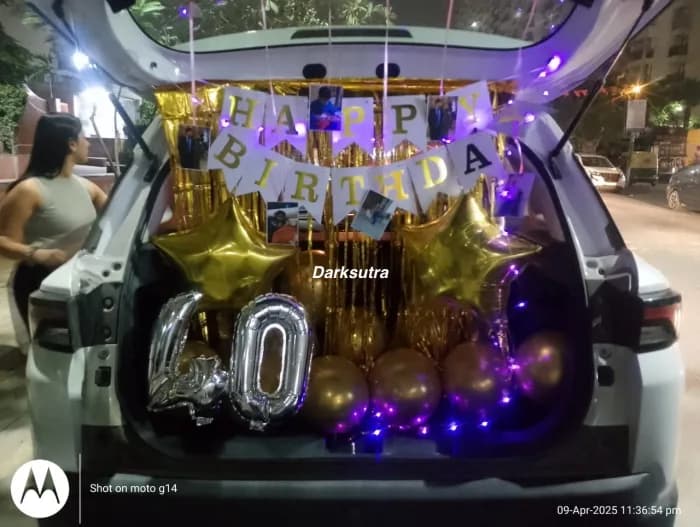Car boot setup with gold star balloons, silver number 40 and purple fairy lights